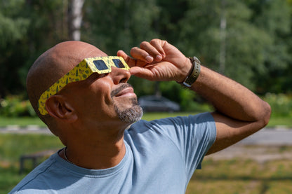 Person wearing Tember Banana solar eclipse glasses outdoors