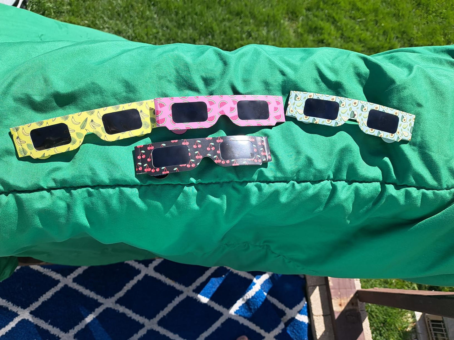 Four Tember fruit-design solar eclipse glasses outdoors